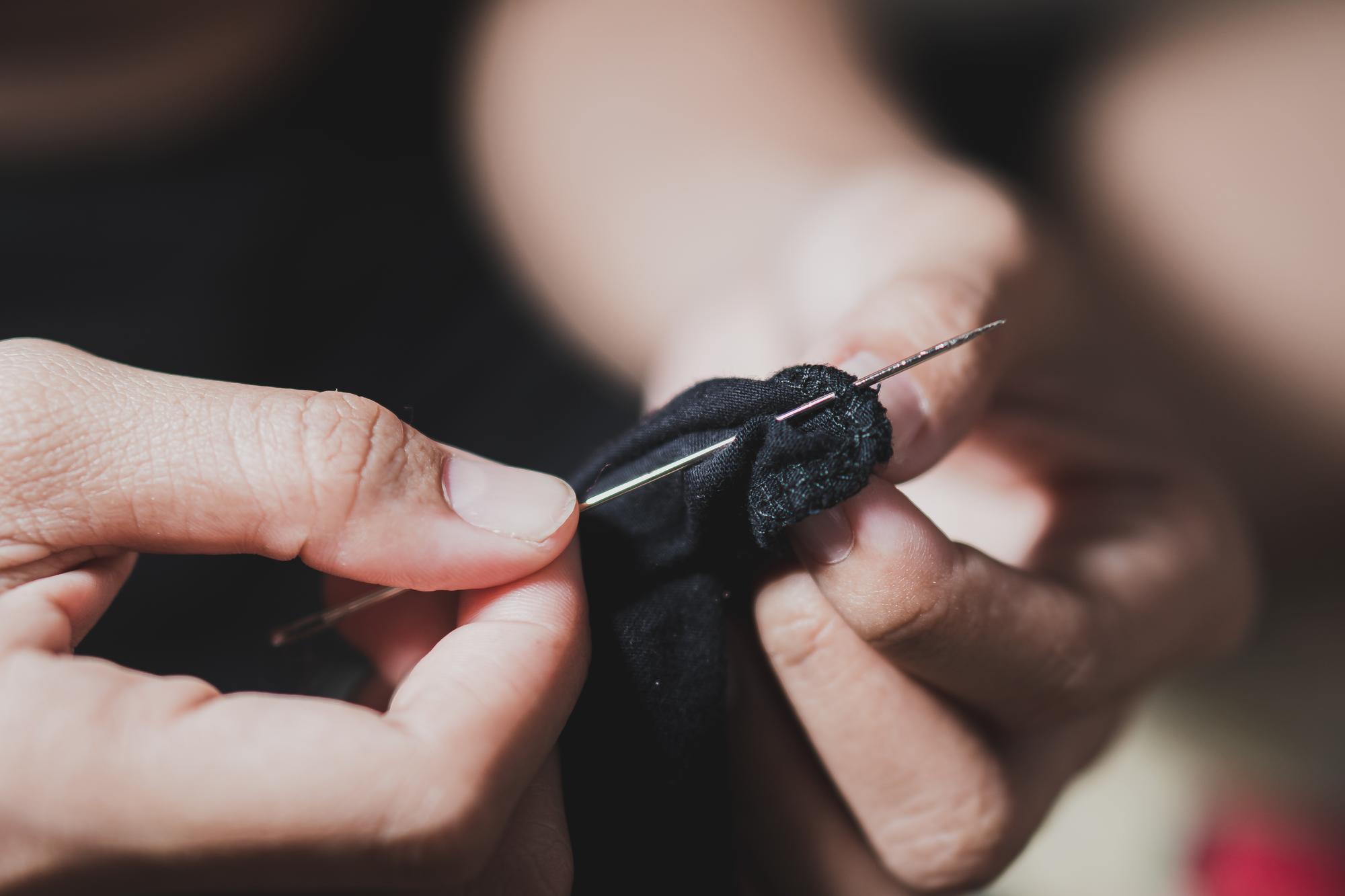 Atelier de broderie - mână cusând un model pe pânză